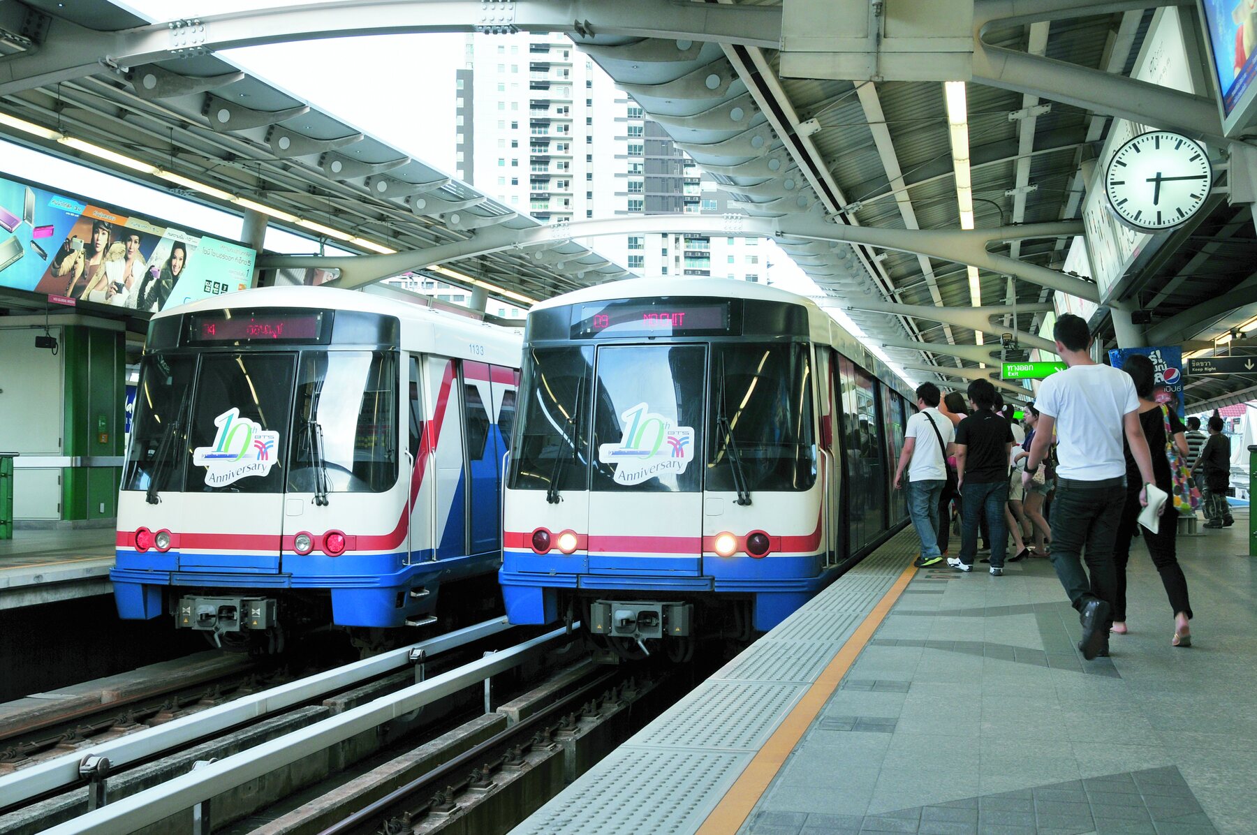 Passengers boarding light rail trains at an elevated platform
